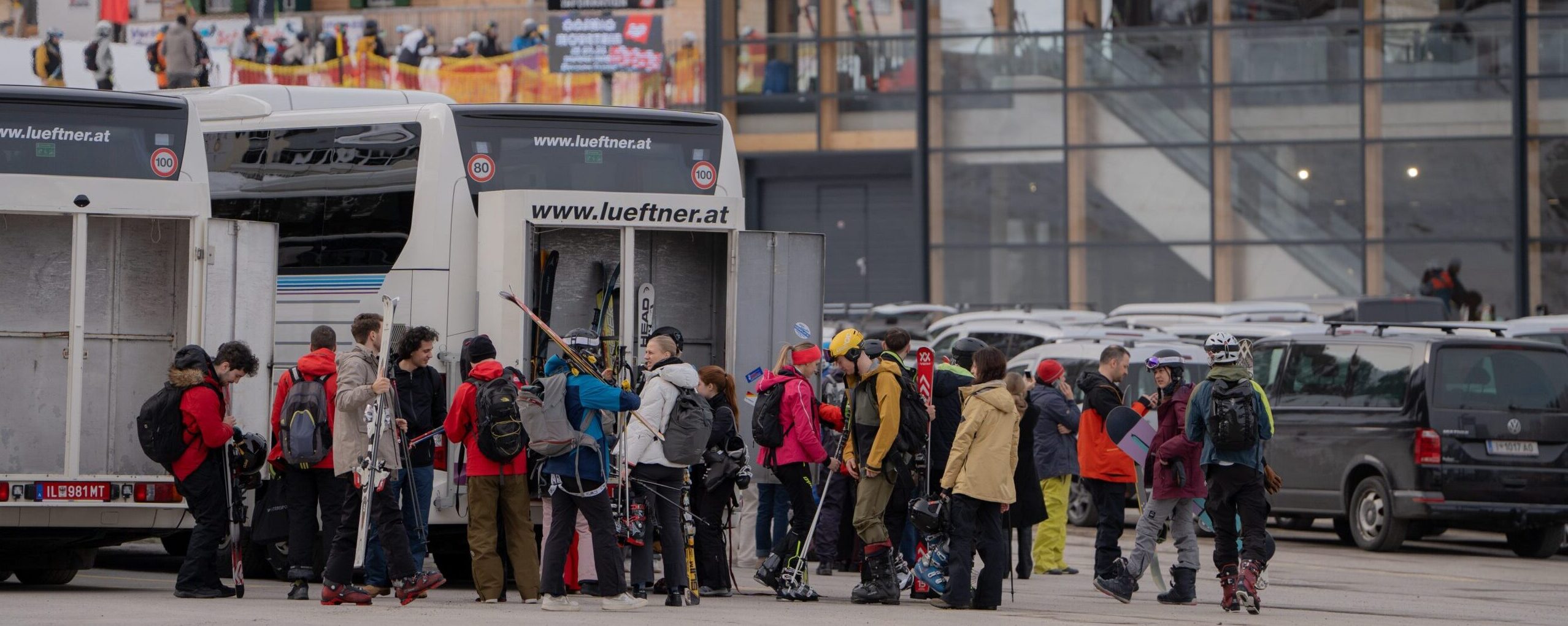 Teilnehmer:innen mit Skiern auf dem Weg zum Skigebiet
